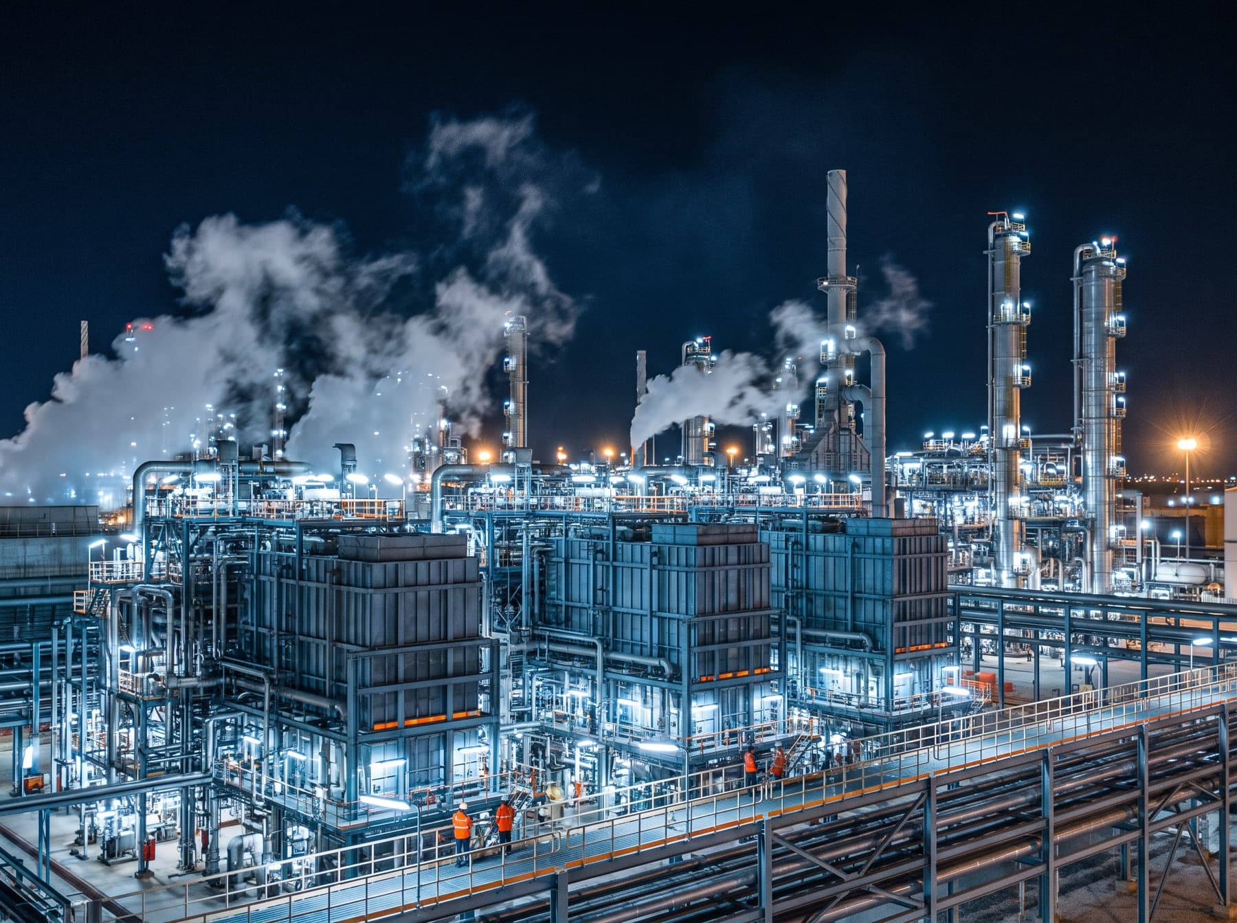 A petrochemical complex at night, its furnaces and columns covered in lights.